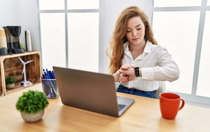 Une salariée regarde sa montre pour calculer son temps de travail de la journée.