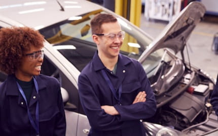 Un groupe de mécaniciens et de mécaniciennes recruté·es pour travailler dans un atelier automobile.