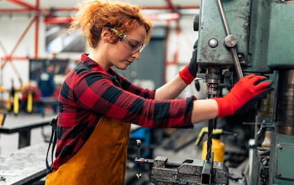 Une jeune salariée dans un atelier industriel, témoin de la féminisation des métiers techniques.